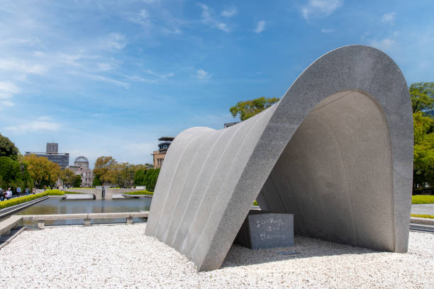 Hiroshima, Japan-April 9, 2023; Close up of the Hiroshima Victims Memorial Cenotaph in the memorial park with the Atomic Bomb Dome in background