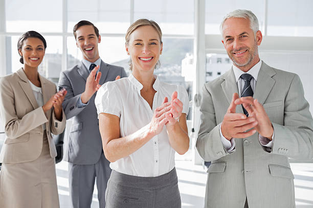 istock Smiling business people applauding together 177840831