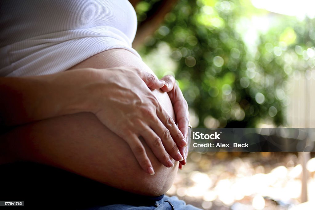 Pregnant Belly Woman holding hadns on pregnant belly Abdomen Stock Photo