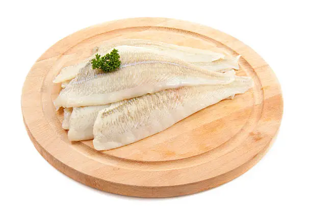 Plaice with parsley on wood isolated over white