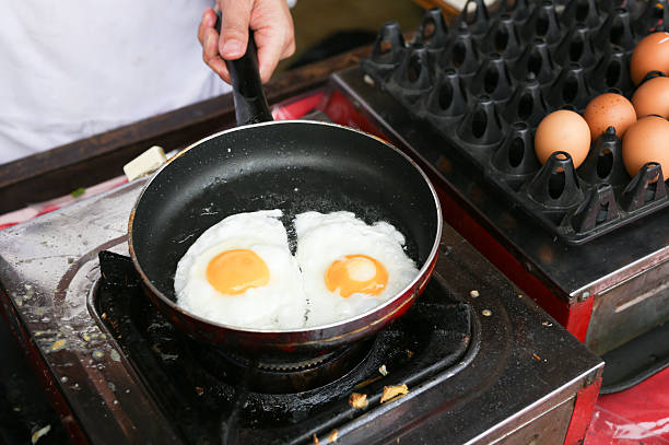 szef kuchni jest gotowanie sunny side up jaj - eggs fried egg frying pan fried zdjęcia i obrazy z banku zdjęć