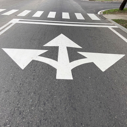 Three arrow sign painted on asphalt road in the city of Caracas