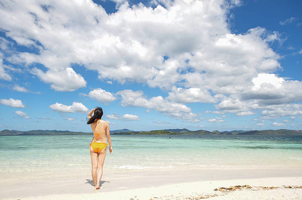 istock young girl stands on white beach 177845208