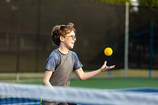 Boy on court playing Pickleball.