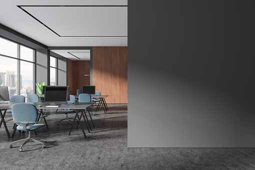 Stylish workspace interior with pc computers, coworking room with armchairs and table on grey concrete floor. Panoramic window on Kuala Lumpur. Mockup copy space wall. 3D rendering