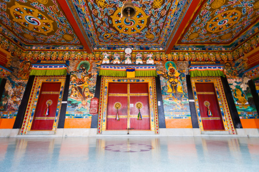 A low angle view of the beautifully painted doors and ceiling of the entrance to Rumtek monastery, the seat of the Karmapa located in Gangtok, Sikkim, India