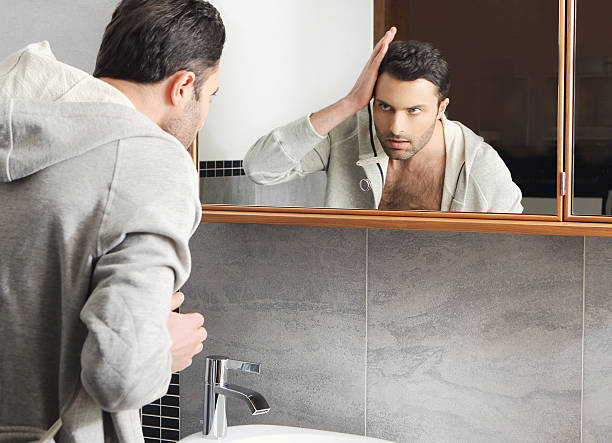 istock Young man looks at himself in the mirror 177846685