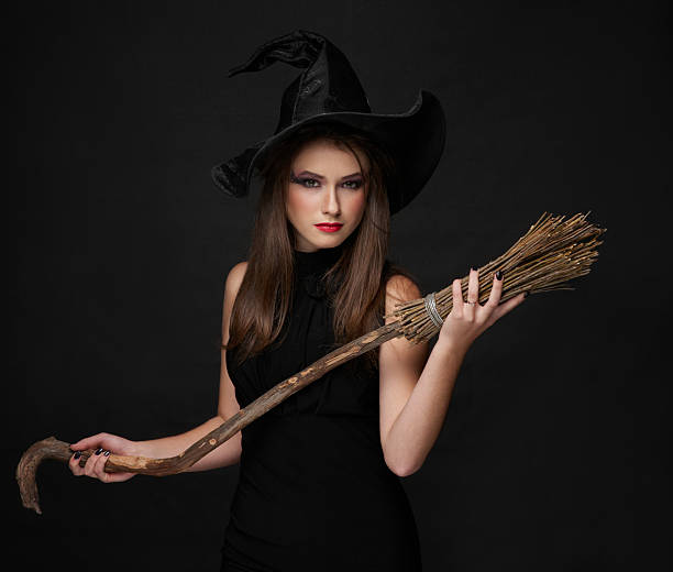 istock The  brunette witch with a broom in studio 177847002
