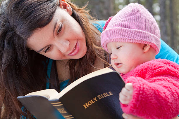 Mom And Baby Daughter Reading Bible Baby girl and mom reading KJV Bible (King James Version) bible verses about family stock pictures, royalty-free photos & images