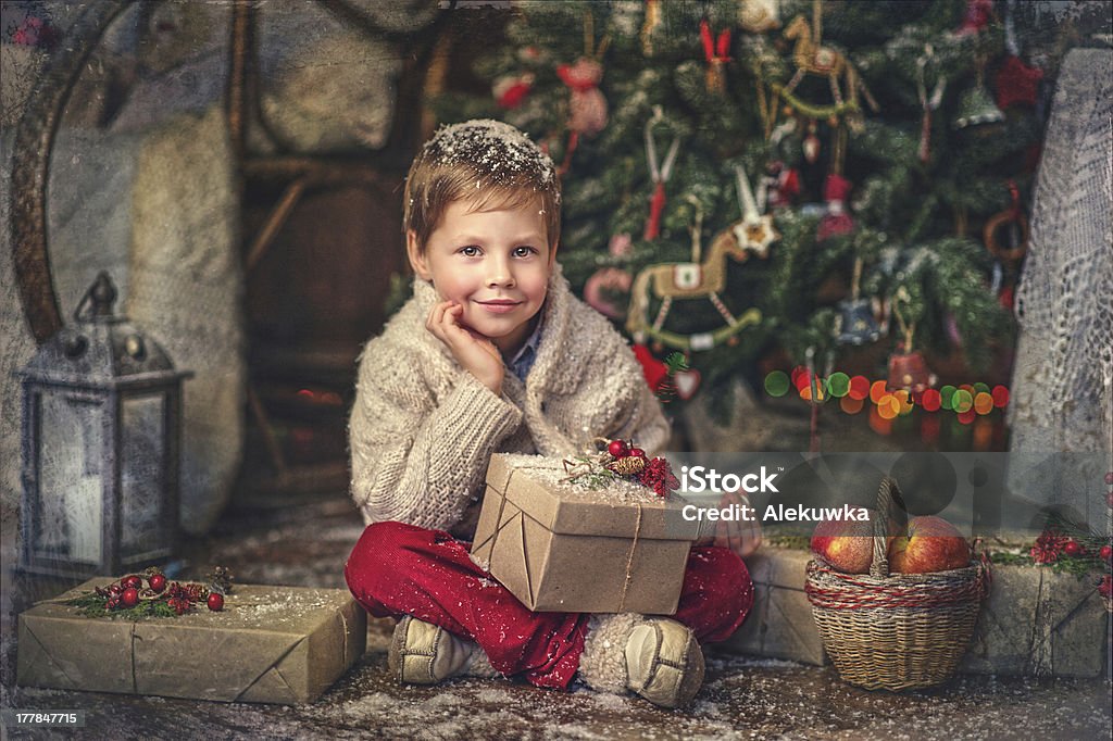 Christmas gifts Christmas-tree sits under a wonderful boy with gifts Apple - Fruit Stock Photo