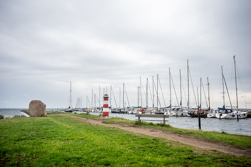 A picturesque view of the serene and charming Orth Harbor on Fehmarn Island. The tranquil waters reflect the colorful boats and the surrounding coastal buildings, creating a soothing and idyllic scene. This image encapsulates the maritime spirit and coastal beauty that define Orth Harbor, inviting visitors to savor the peaceful atmosphere of this lovely destination.