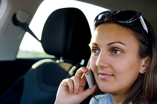 mujer usando su teléfono móvil en el coche - equanimity fotografías e imágenes de stock