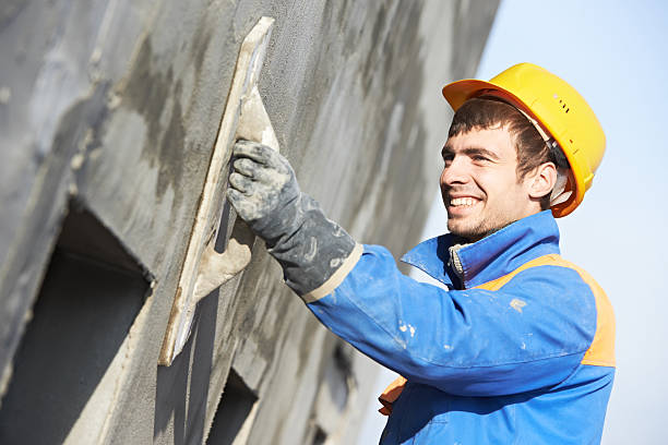 facade builder plasterer at work builder worker plastering facade industrial building with putty knife float steeplejack stock pictures, royalty-free photos & images