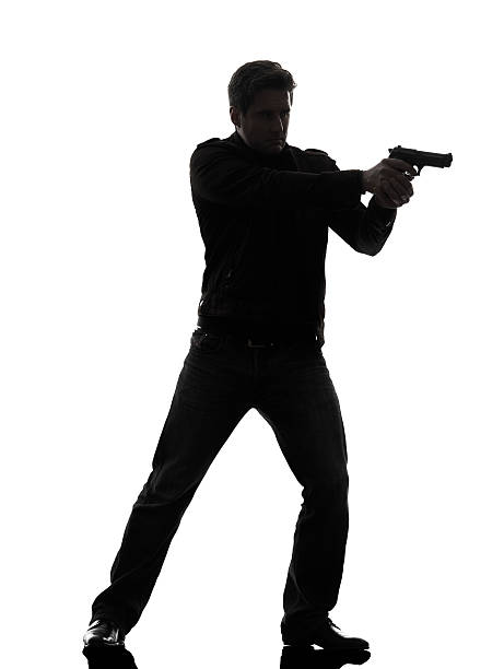 homme killer policier viser pistolet silhouette de standing - gun men holding handgun photos et images de collection