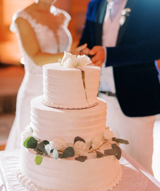 istock Bride and groom cut the wedding cake on the table. Cropped. Faceless 1778493995