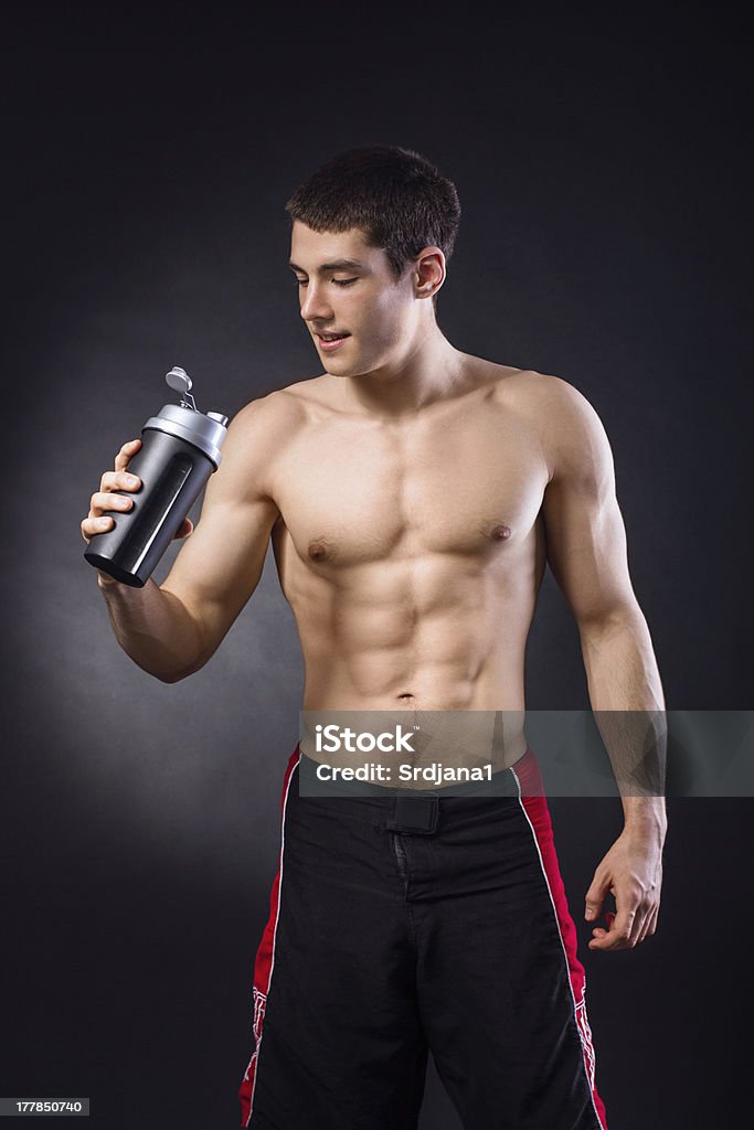 Мышечная молодой человек держит белок shake с открытой грудью - Стоковые фото Мужчины роялти-фри