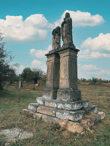 Ancient stone statues in abandoned cemetery. Headless statue. Old cemetery.