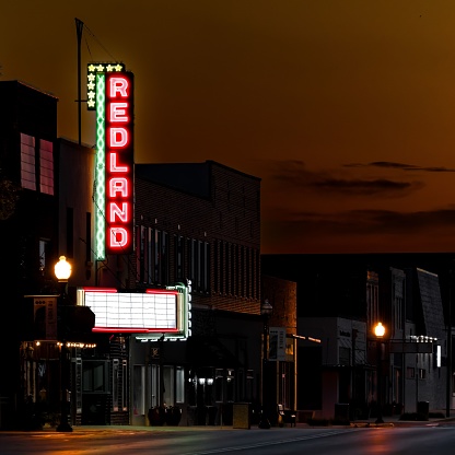 Oklahoma City, United States – July 05, 2022: A nighttime cityscape featuring a lit-up sign on the side of a city street
