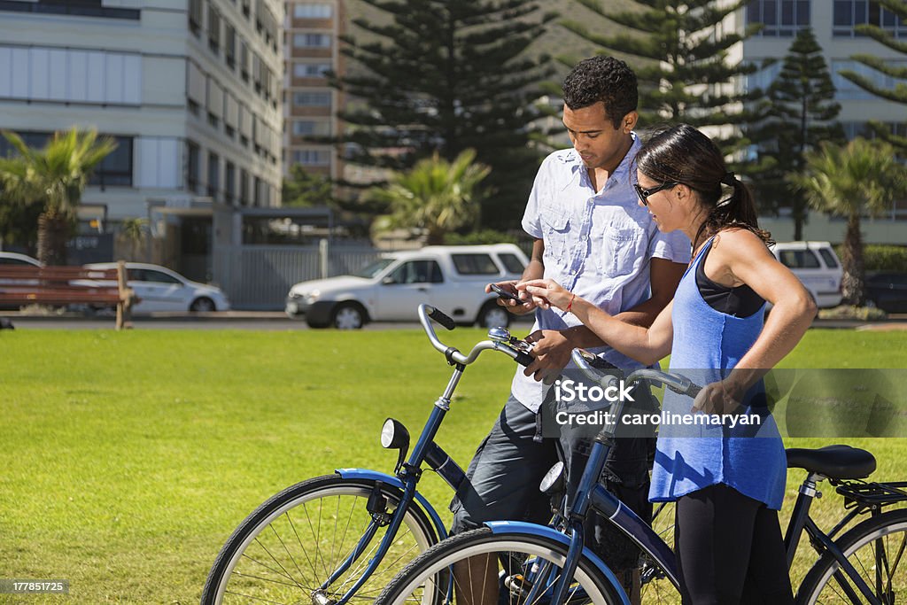 カップル、自転車の携帯電話をチェック - 20代のロイヤリティフリーストックフォト