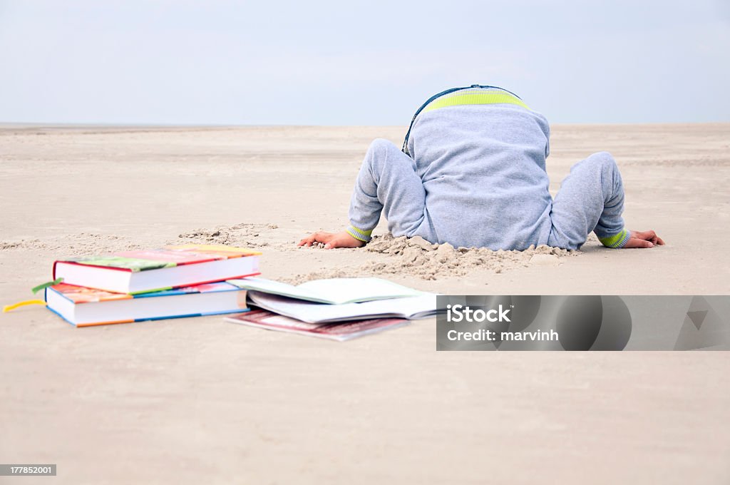 Desmesurado criança stucks cabeça na areia - Foto de stock de Cabeça enterrada na areia royalty-free