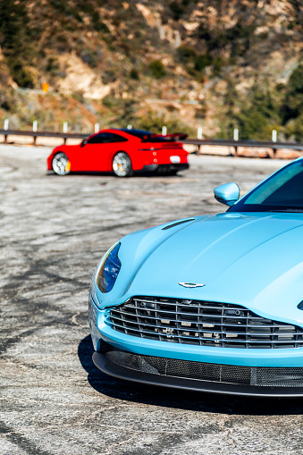 LA, CA, USA\n11/5/2023\nAston Martin DB11 in blue showing the car parked with a red car in the background