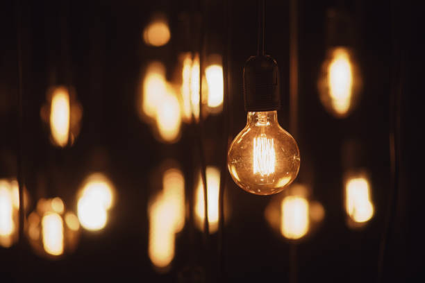 istock Vintage light bulbs decor glowing in dark room. Lighting decor. 1778528616