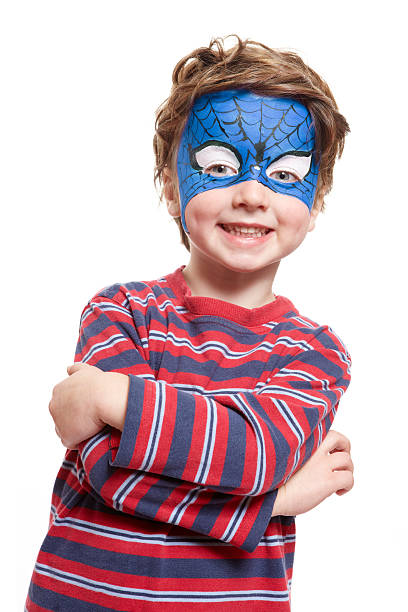 woman painting face of kid outdoors