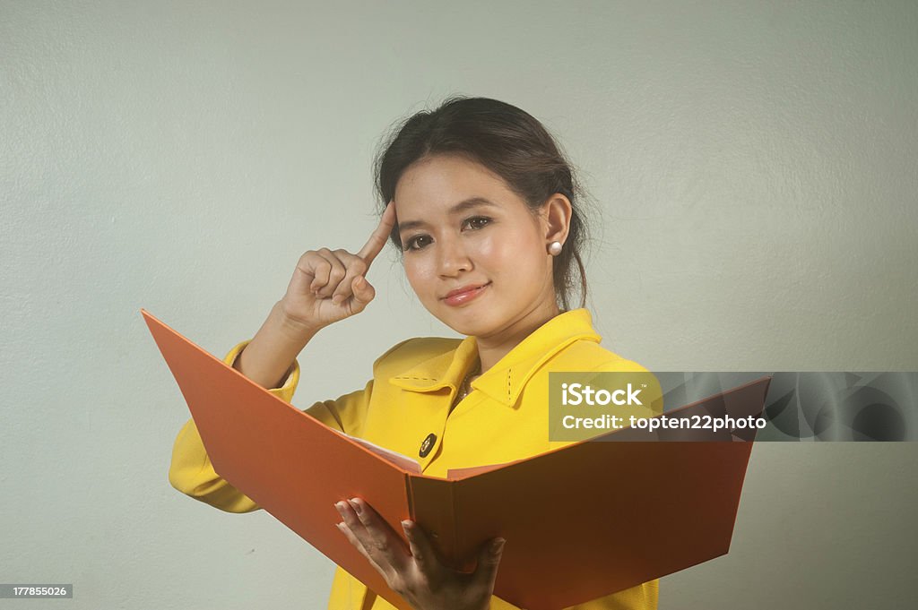 Schöne asiatische Geschäftsfrau ruminated und hält eine Datei. - Lizenzfrei Akte Stock-Foto