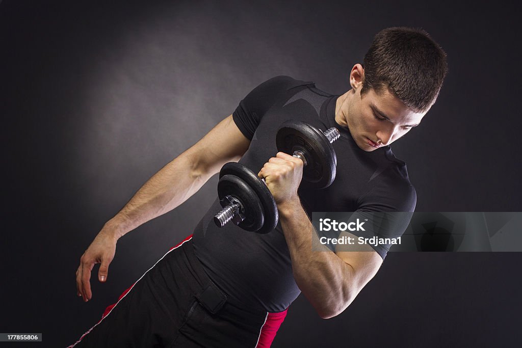 Giovane uomo muscolare facendo allenamento con pesi - Foto stock royalty-free di A petto nudo