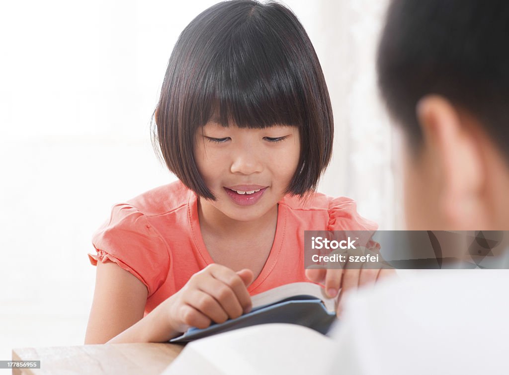 Ази�атские дети читать книгу на дому - Стоковые фото Азиатского и индийского происхождения роялти-фри