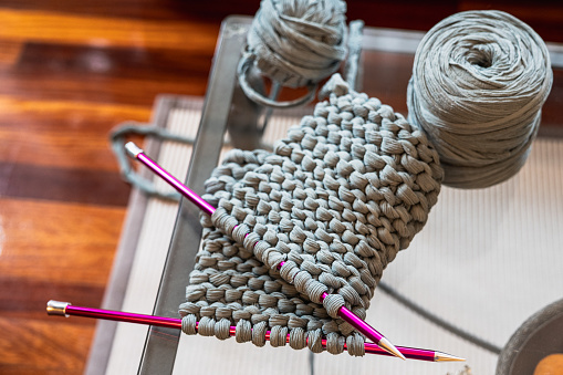 Close-up of the needles and the wool with which the sweater is being made