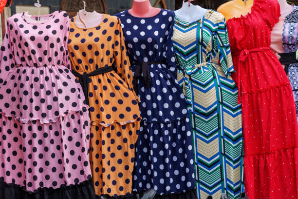 female manequins aligned wearing colourful ladies dresses female manequins displaying ladies dresses with a variety of designs colours and patterns tivoli bazaar stock pictures, royalty-free photos & images