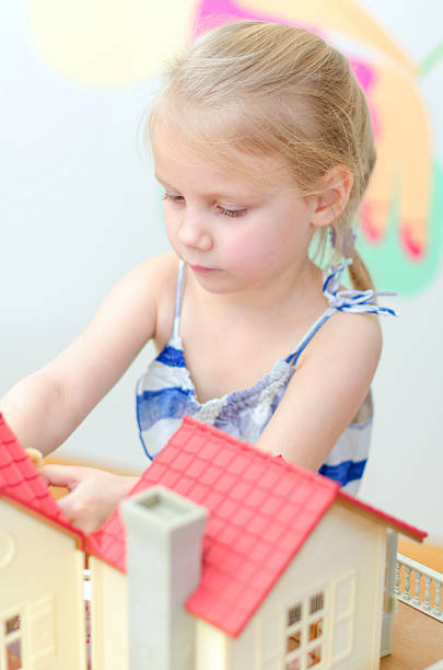 istock Little girl playing with dollhouse 177859538