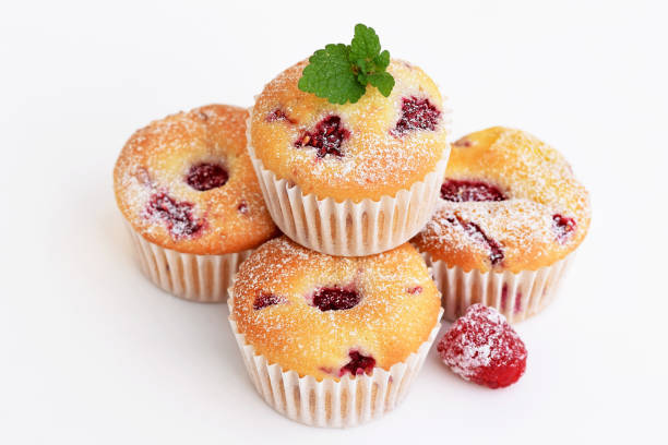 Muffins with raspberries on white background