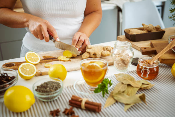 Woman preparing healthy ginger and lemon tea