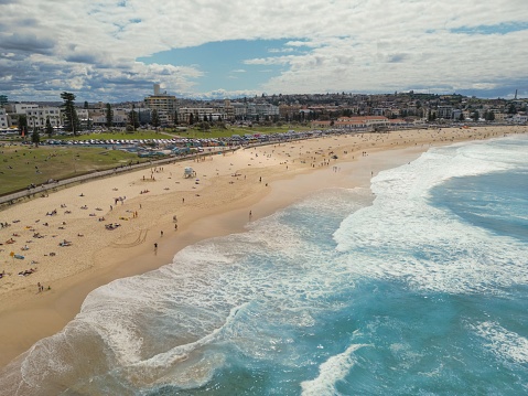 An aerial view of a beach with people enjoying their day near the tranquil ocean. Bondi, Australia