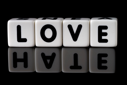 Love spelled in dice with the word hate reflected on black isolated background