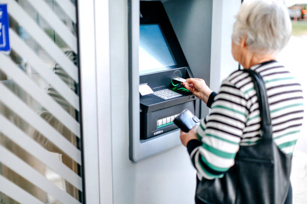 istock Old woman picking money using ATM 1778639833