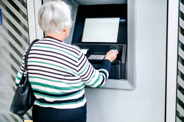 istock Old woman picking money using ATM 1778640338