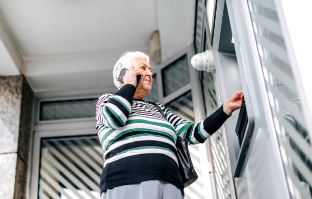 istock Old woman picking money using ATM 1778643038
