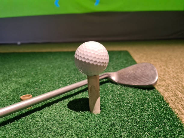 istock Golf ball on tee and golf club on green background 1778664108