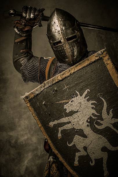 istock Medieval knight with sword and shield against stone wall 177866794
