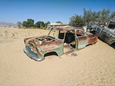 Rusty abandoned car on desert sand in Solitaire, Namib Desert, Namibia