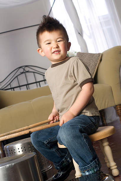 istock Happy Young Boy Plays Beats Kitchen Pots Pans Like Drums 177866884
