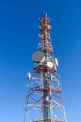 Telecommunications mast with lots of microwave dishes, dipole antenna and other radio equipment, Namibia.