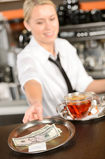 Attractive waitress taking tip in bar USD stock photo