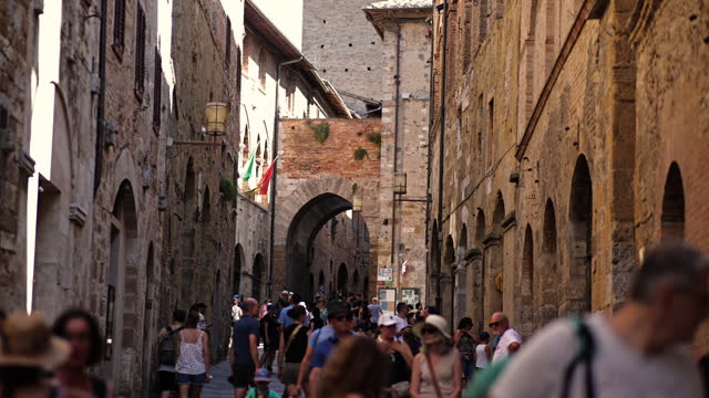 View of the town of San Gimignano in Tuscany Italy with summer weather, the town of San Gimignano in Tuscany, one of the most beautiful medieval towns of Tuscany, Italy, A crowded tourist street in San Gimignano