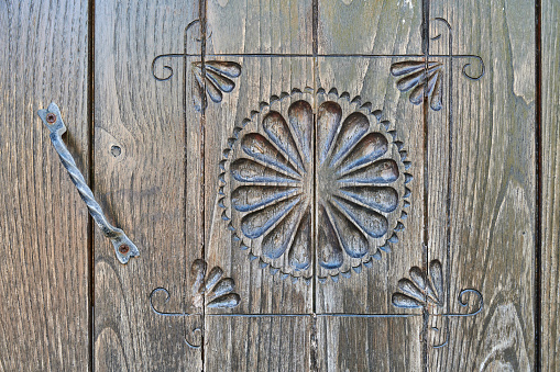Peacock carving form handmade on the large wooden door of the countryside house.