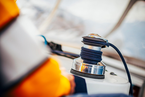 Electrical winch with rope on sailing boat during sailing.