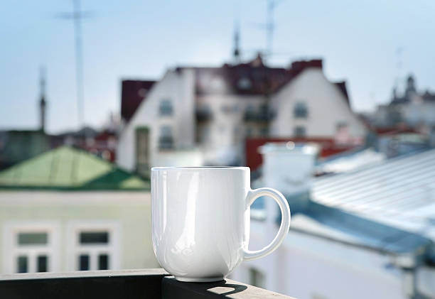 istock White cup stands on balcony railing above blurred cityscape 177868930